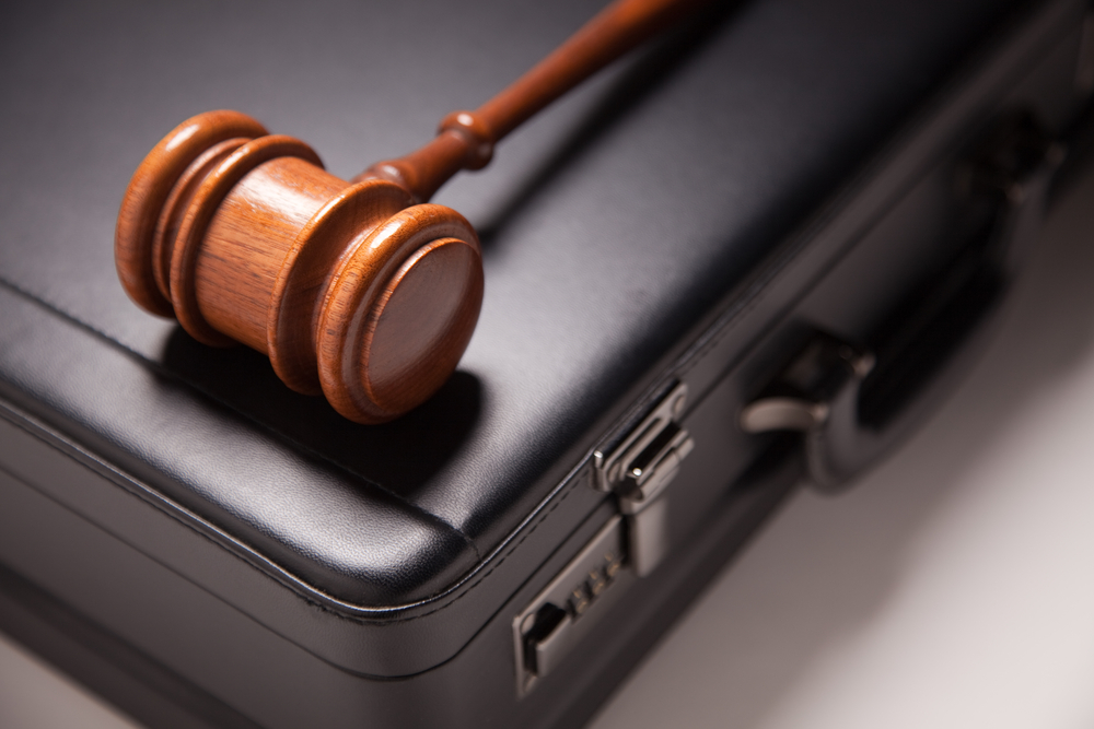 Personal Injury Lawsuits For Deceptive Trade Practices - Gavel and Black Briefcase on Gradated Background with Selective Focus - Business Law Concept.